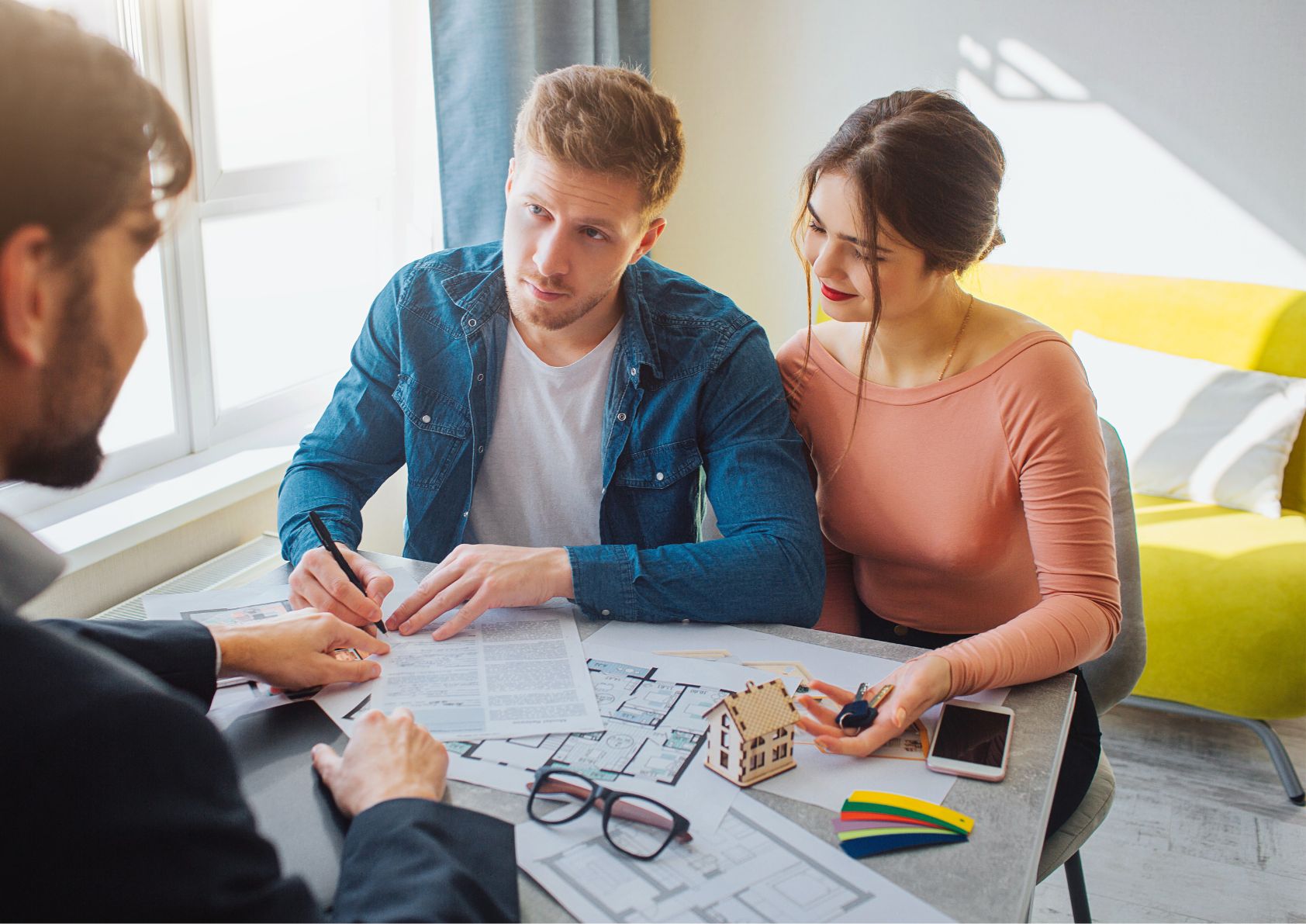 Couple with a mortgage lender discussing interest rates for a home purchase. 