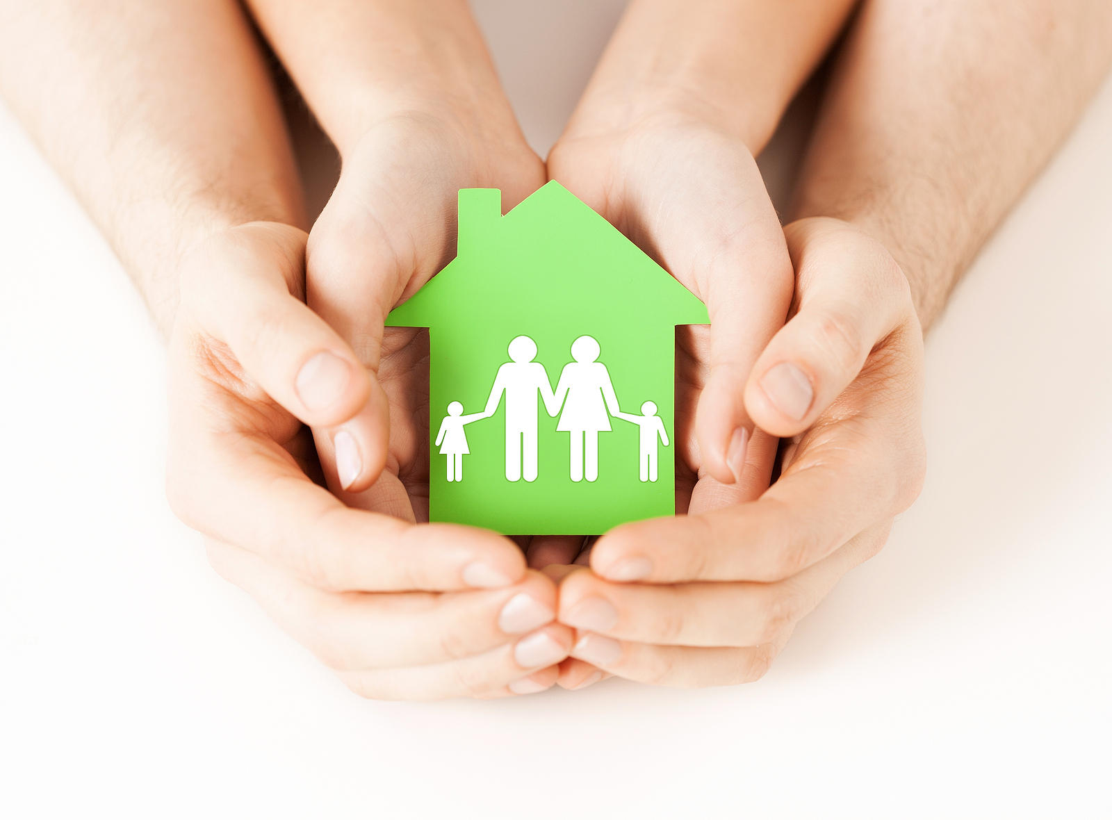 real estate and family home concept - closeup picture of male and female hands holding green paper house with family. Representation of eco home. 